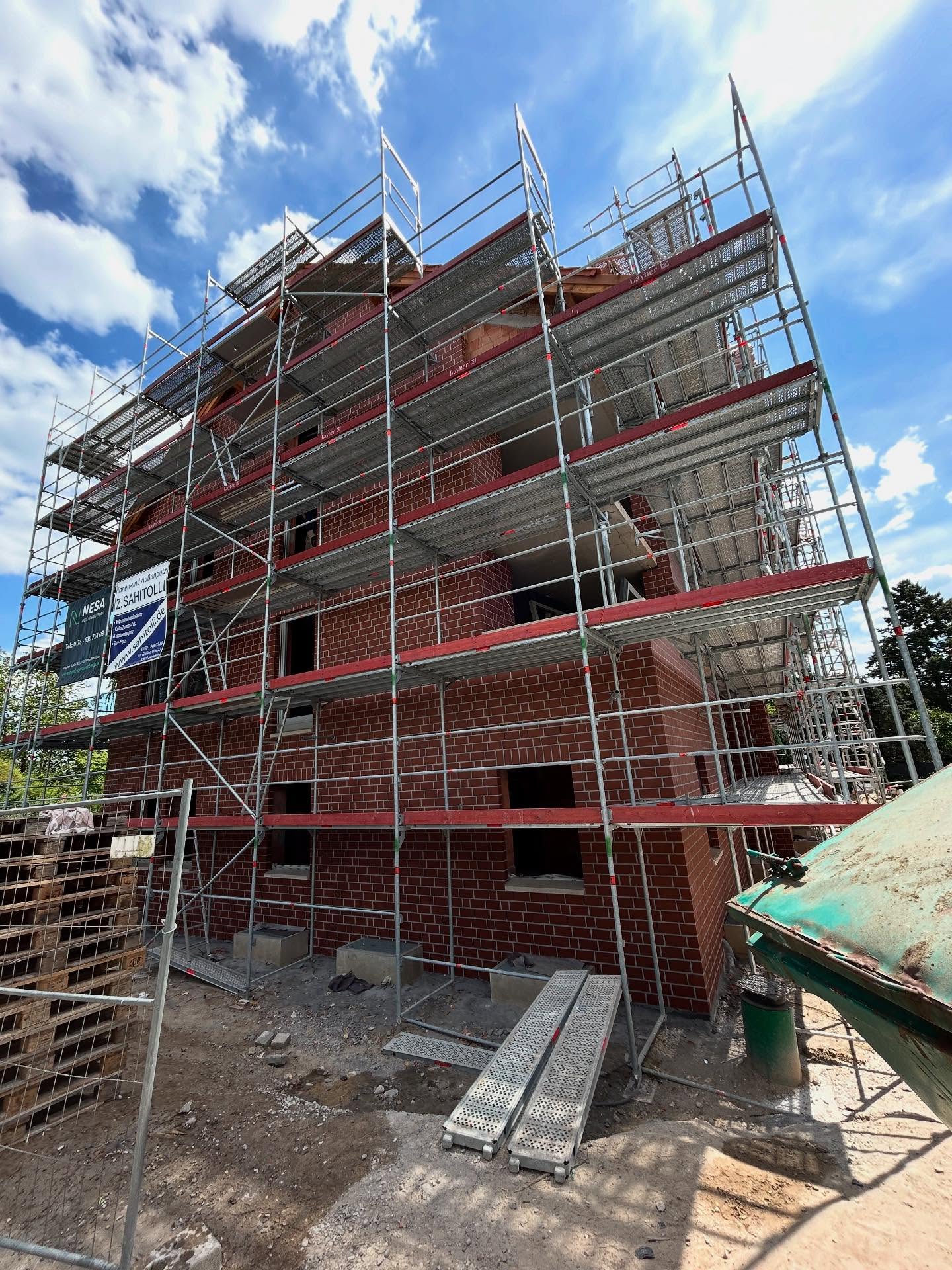 Rotes Klinkergebäude mit mehrstöckigem Arbeitsgerüst