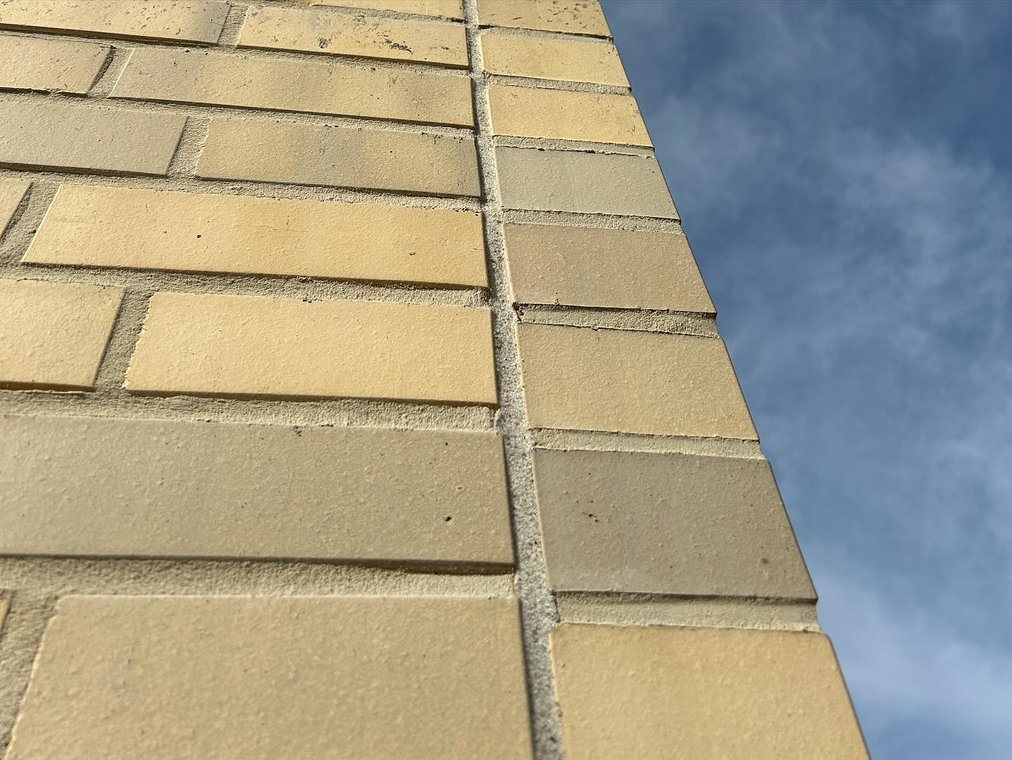 Nahaufnahme verfugter heller Platten an einer Fassade
