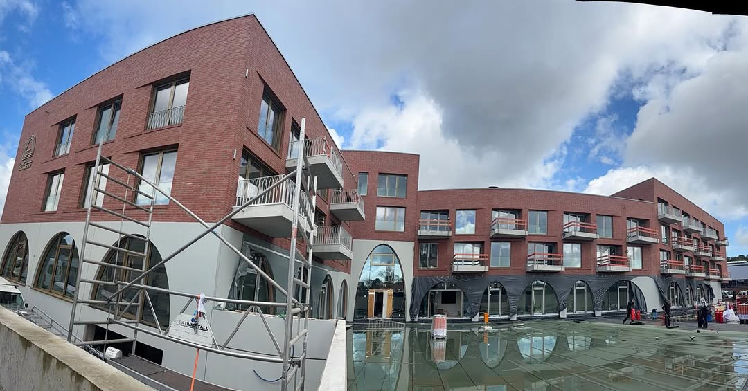 Rotverklinkerte Wohnanlage mit Bogenbalkonen und Gerüst