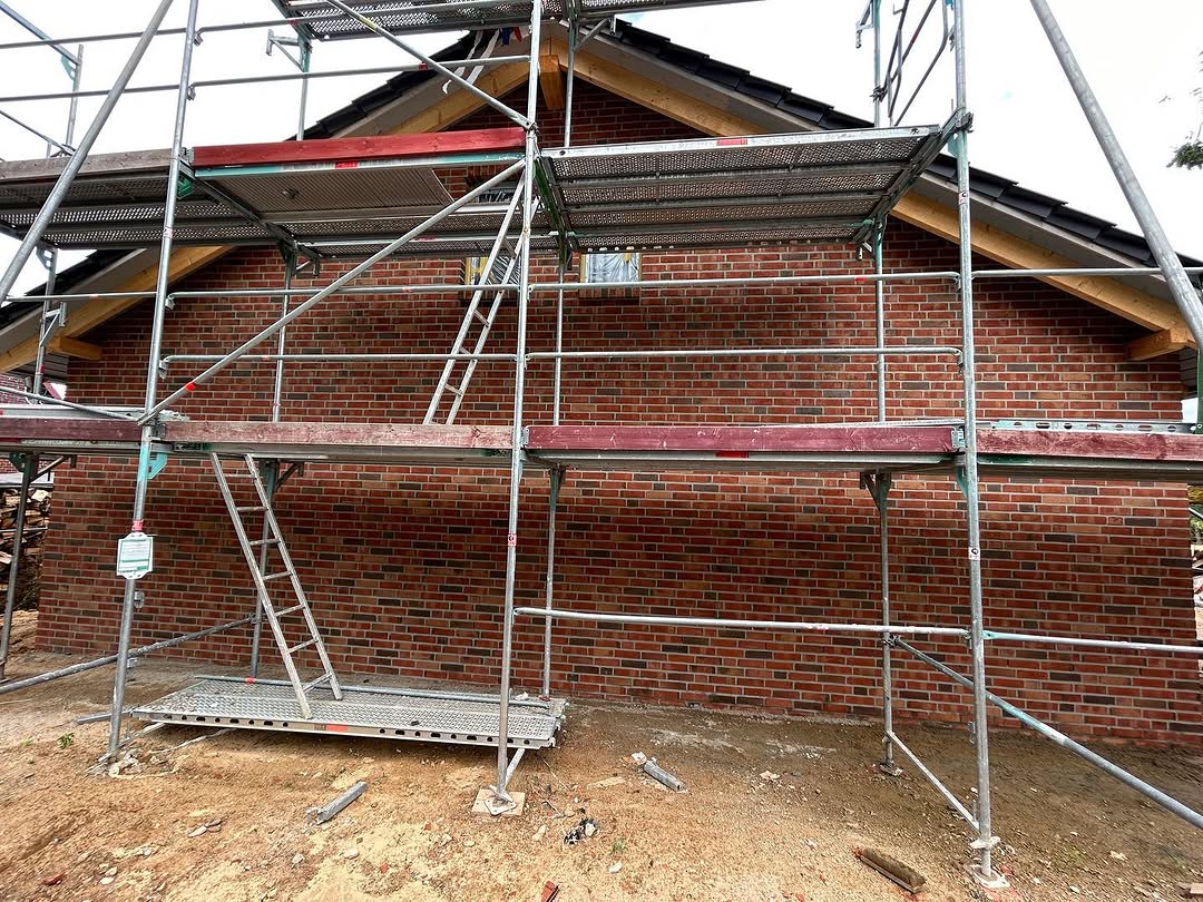 Ziegelmauerwerk an der Giebelseite eines Hauses mit Gerüst