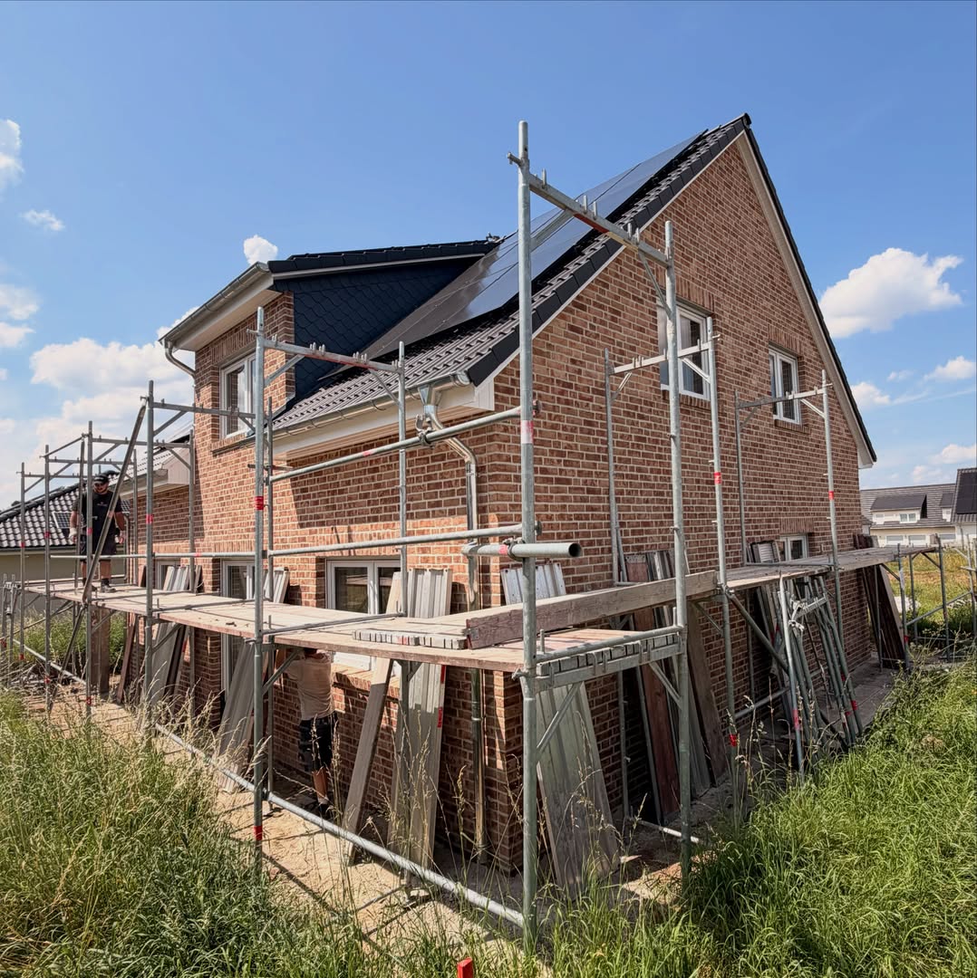 Ziegelhaus mit Solaranlage und Baugerüst