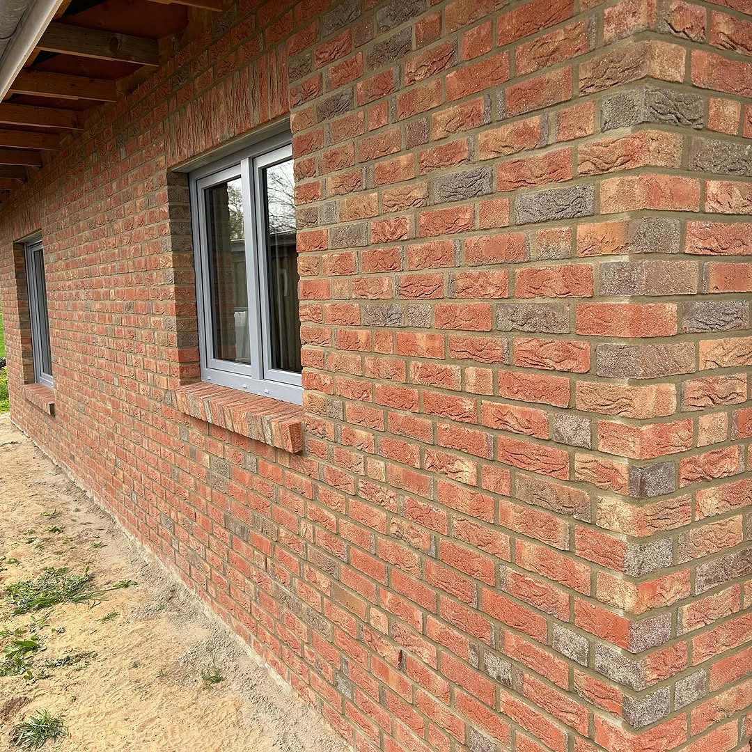 Fenster und Gebäudeecke mit rotem Ziegelmauerwerk