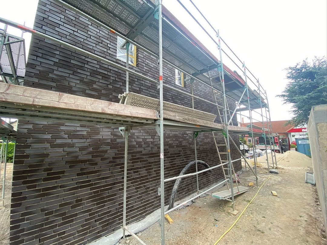 Dunkle Klinkerfassade hinter einem Baugerüst