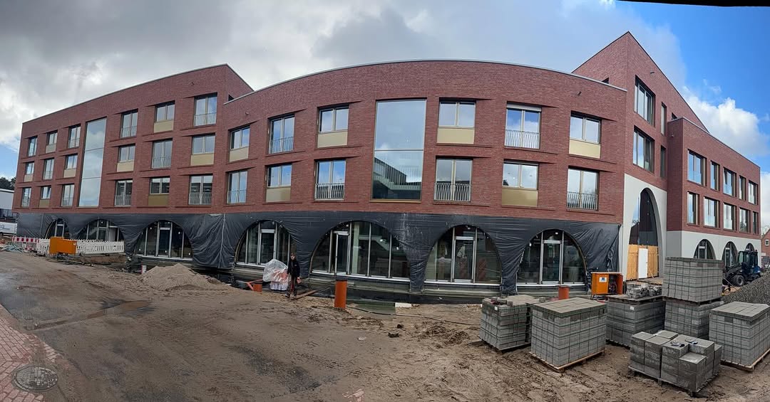Geschwungene Rotklinkerfassade mit Bogenloggias im Bau