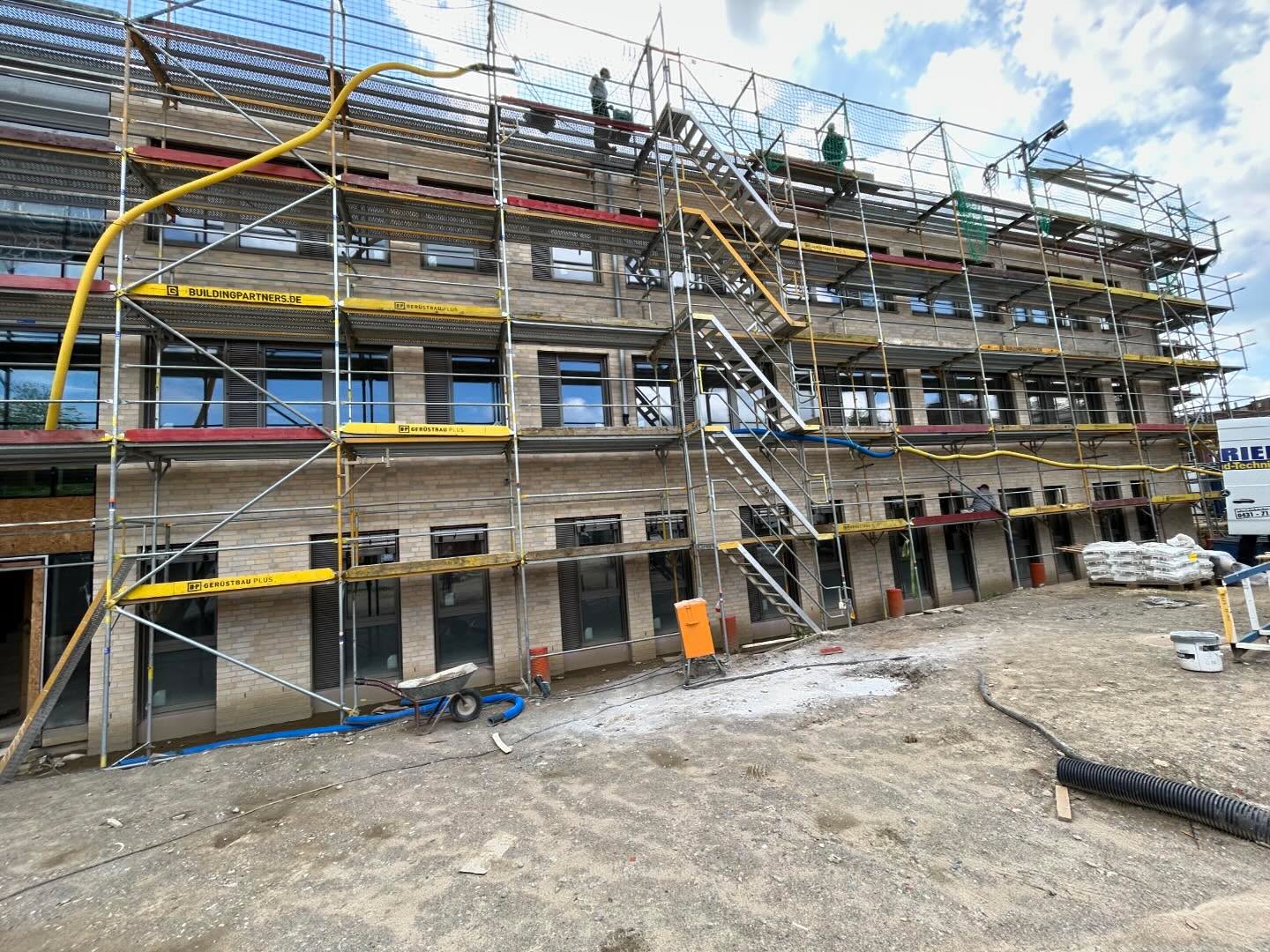 Mehrgeschossiges Gebäude mit Gerüst und dunklen Fensteröffnungen
