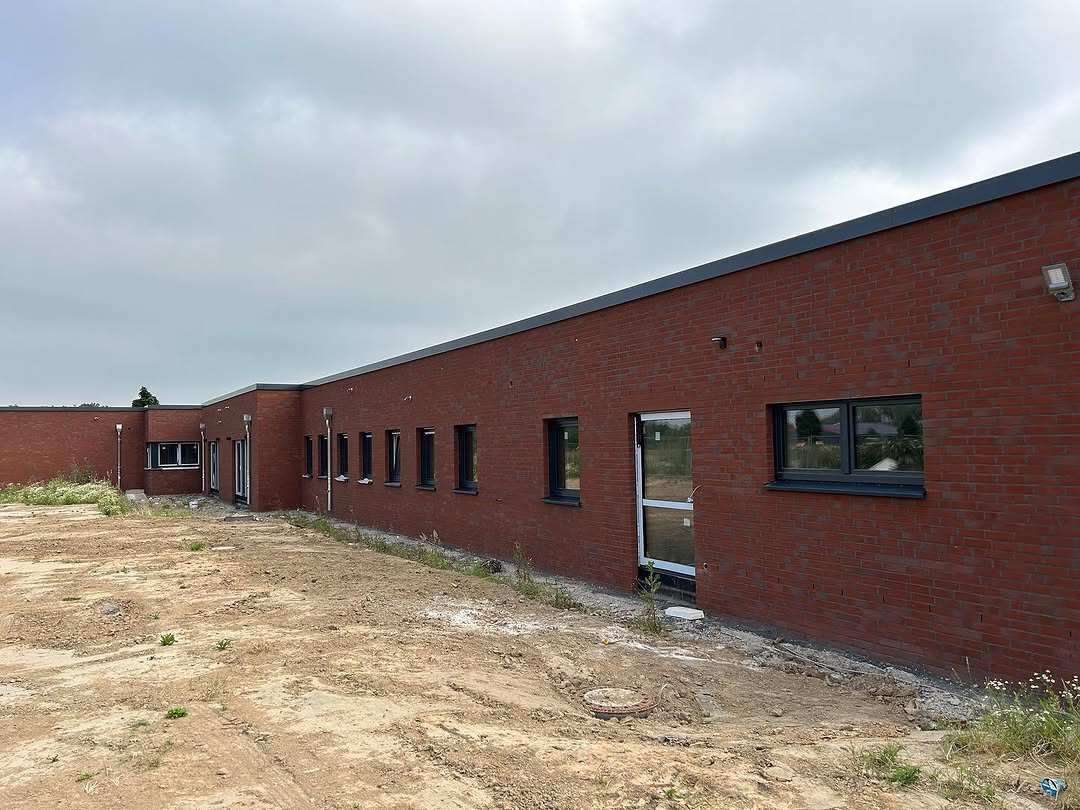 Lange rote Klinkerfassade mit Fensteröffnungen