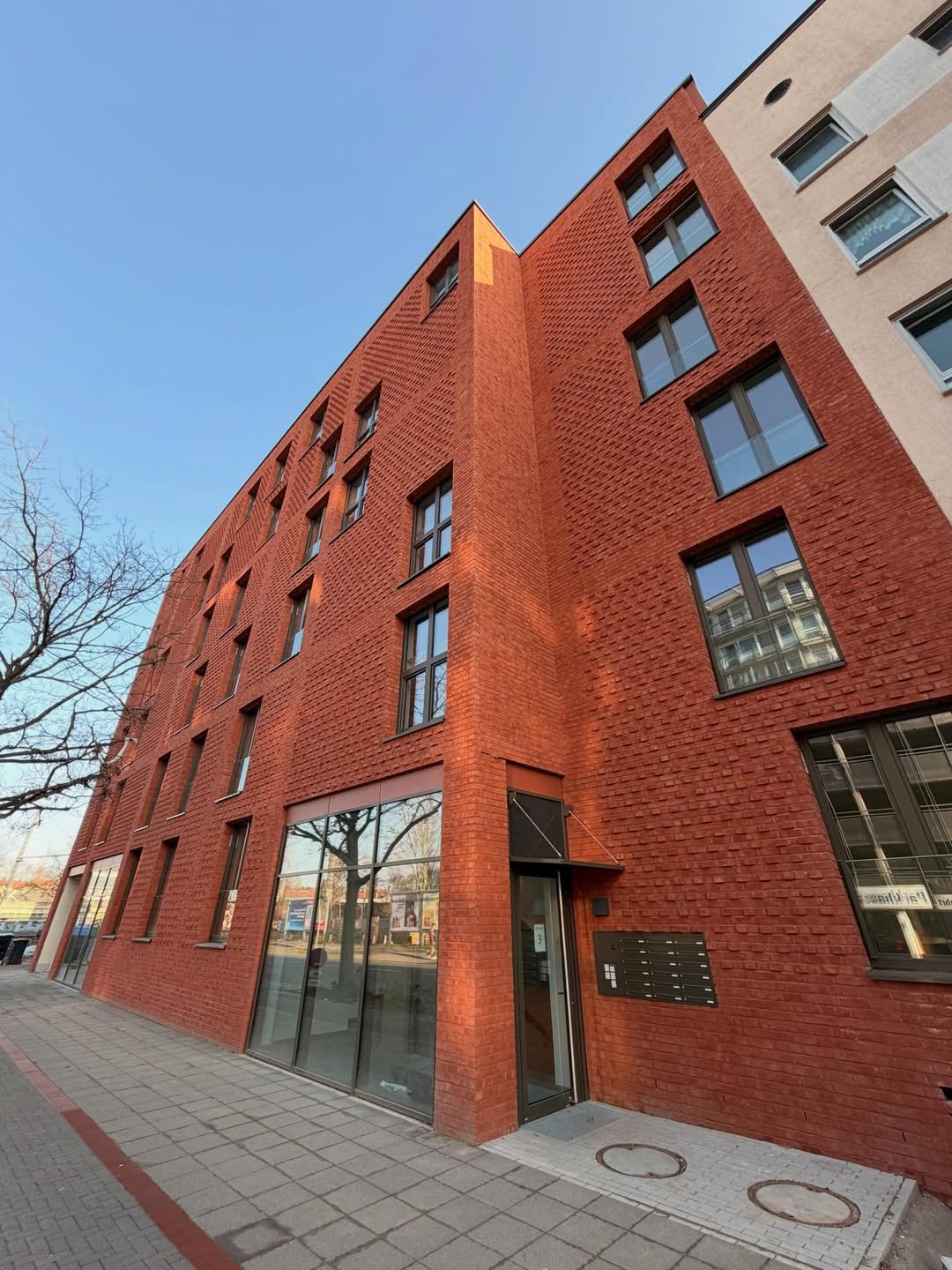 Rotverklinkertes Wohngebäude mit Glasfront im Erdgeschoss