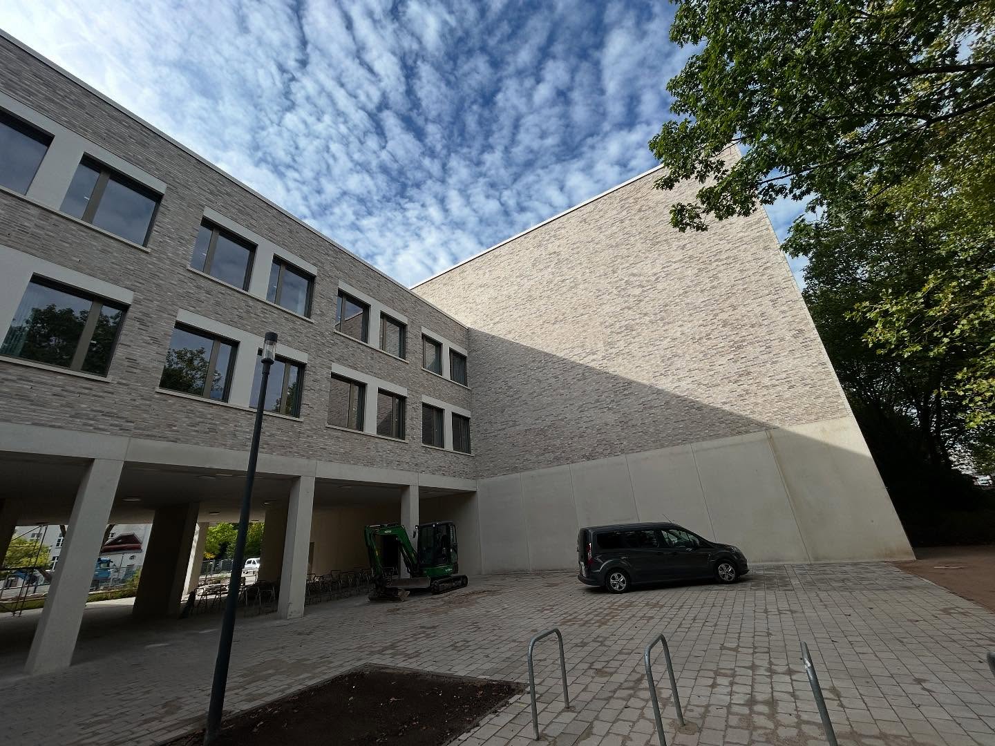 Graues Klinkergebäude mit offener Tiefgaragenebene