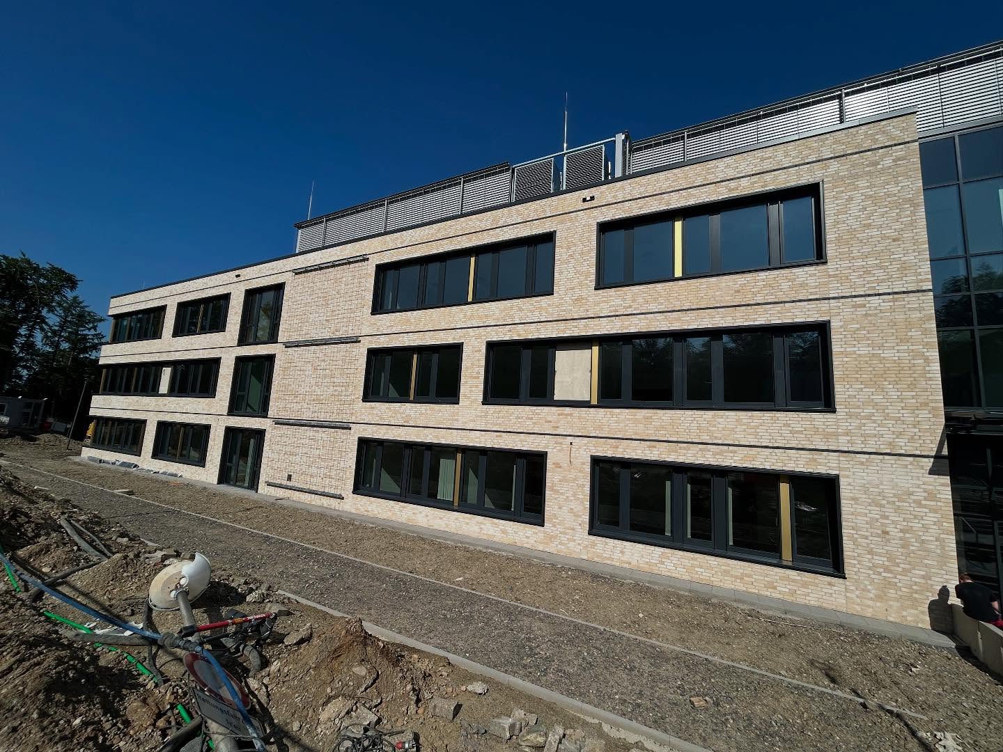 Mehrgeschossige Wohnanlage in hellem Klinker mit schwarzen Fenstern
